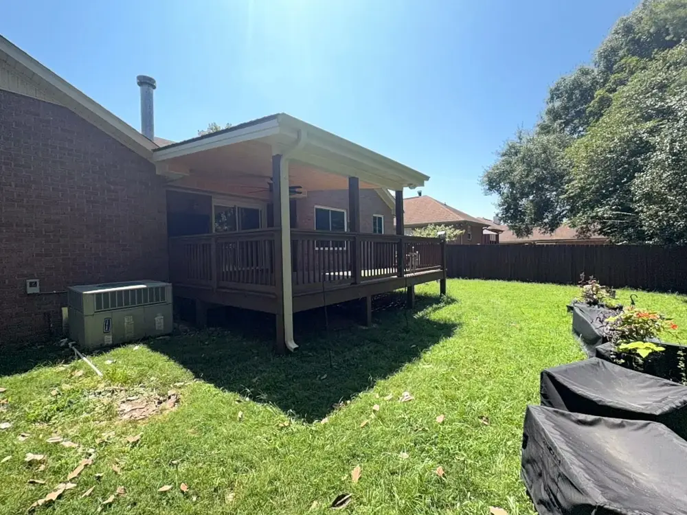 Backyard with a new wood privacy fence and a covered wood deck