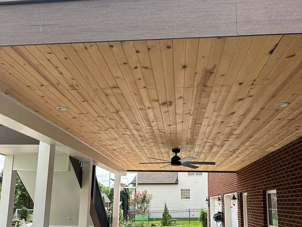 Covered patio under a deck with a wood ceiling and a ceiling fan