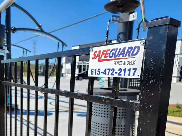 Black aluminum fence at a commercial site with a SafeGuard sign showing 615-472-2117